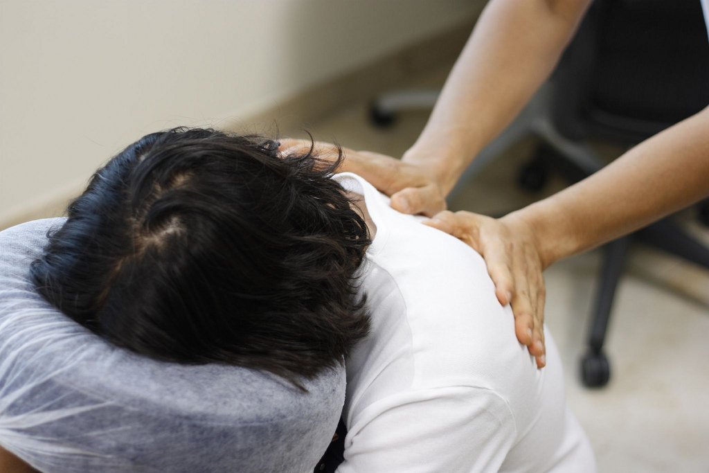 Woman in massage chair receiving a shoulder massage